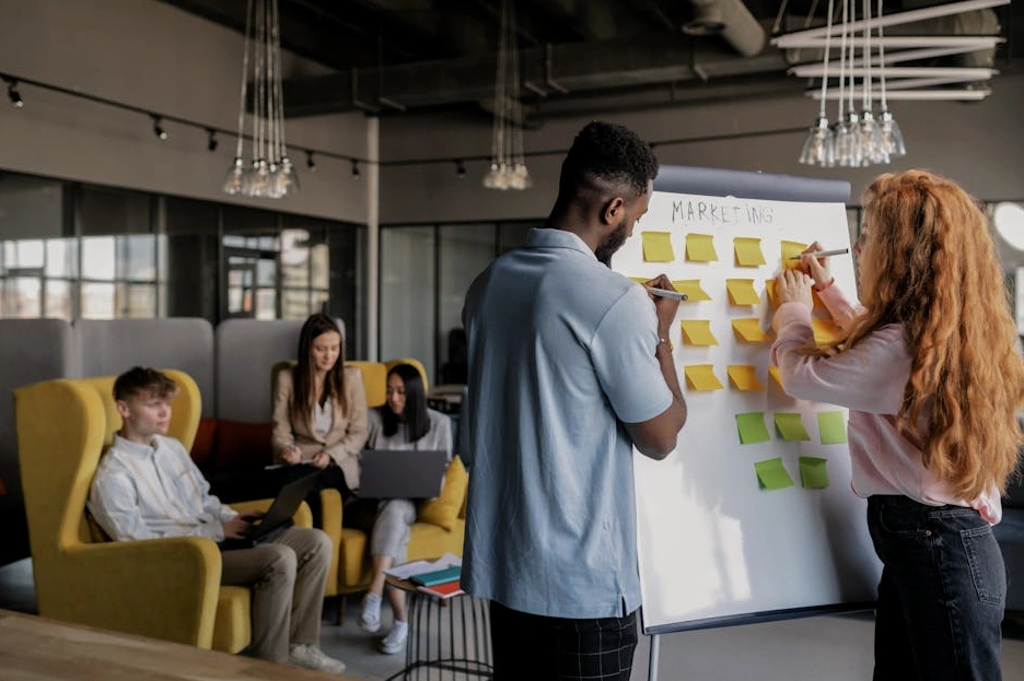 Zespół omawiający projekt przy tablicy w biurze