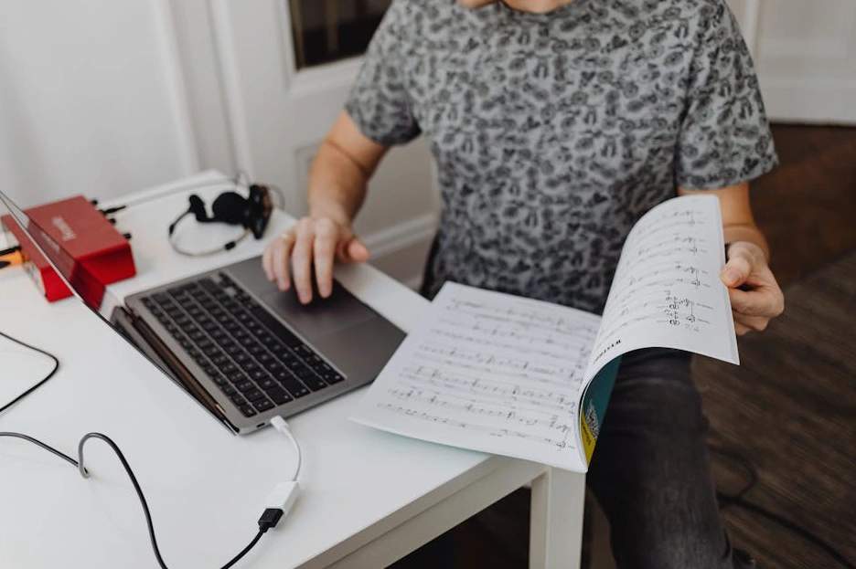 Osoba wypełniająca formularz na laptopie w przytulnym wnętrzu