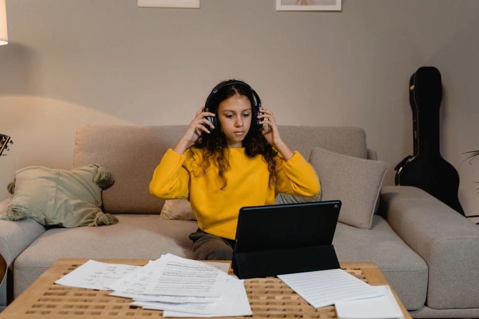 Kobieta oglądająca kurs online na tablecie z notatnikiem